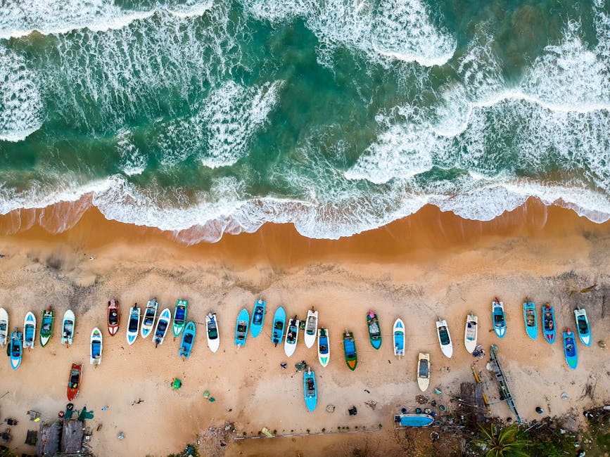 Stunning aerial shot of vibrant boats lined on sandy shores of Arugam Bay, Sri Lanka